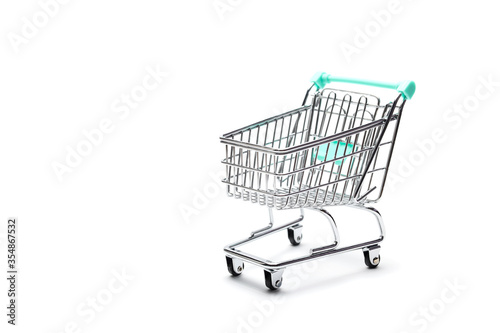 Miniature empty shopping cart on colorful background