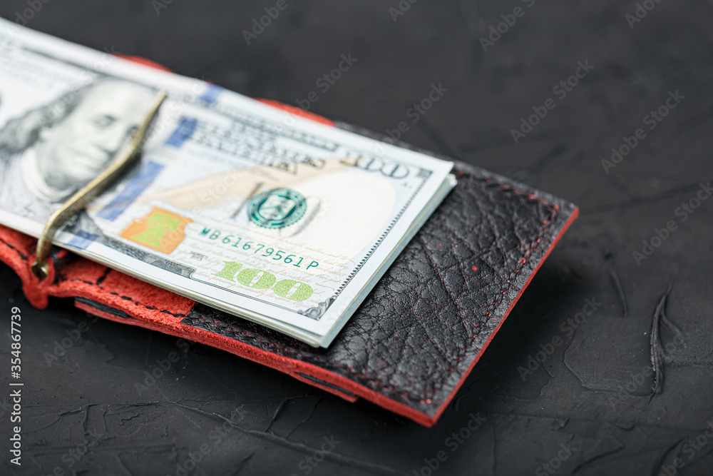 Red purse with new dollars on a black background. Red purse with new dollars on a black background.
