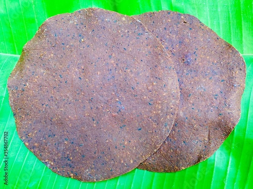 Dried rotten beans sheet stacking on fresh green banana leaf. Northern Thailand culture ingredient for cuisine.
