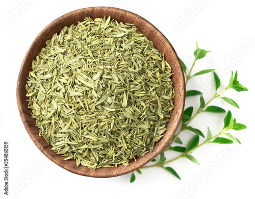 dried thyme leaves in the wooden bowl, with fresh thyme isolated on white background, top view