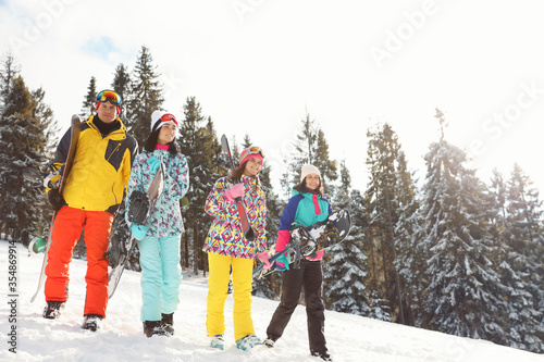 Group of friends with equipment on snowy slope. Winter vacation