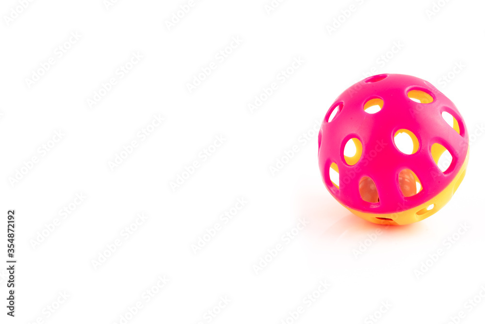 Orange and pink cat toy ball with a bell inside, isolated on a white background