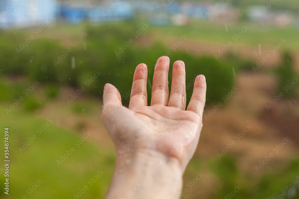 Palm hands with water splash. Nature rain drop, environmental and freshness concept.Girl holding out her hands to the rain. Palm hands with water splash. Nature rain drop, environmental and freshness concept.Girl holding out her hands to the rain.