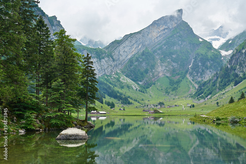 Fototapeta Naklejka Na Ścianę i Meble -  Landscape panorama from Seealpsee, Alpstein range of the canton of Appenzell, Switzerland. Green nature, mountains and their reflections on the lake.