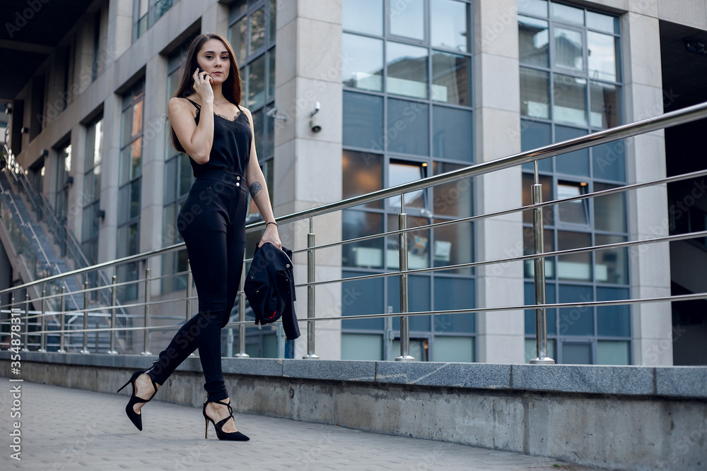 Business Woman With Phone Near Office. Portrait Of Beautiful Smiling Female In Fashion Office Clothes Talking On Phone While Standing Outdoors. Phone Communication. High Quality Image.