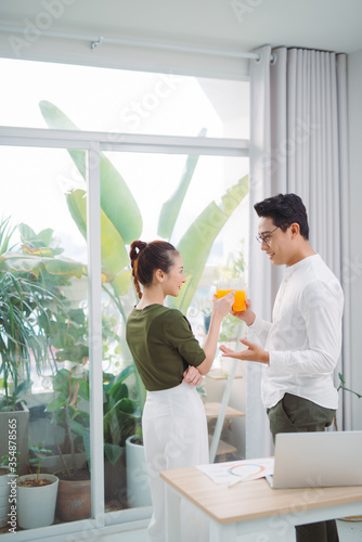 Beautiful young couple in office, using laptopo photo