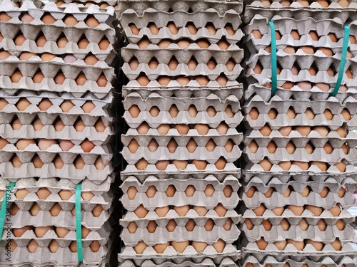 A lot of eggs in paper package at hypermarket for sale.