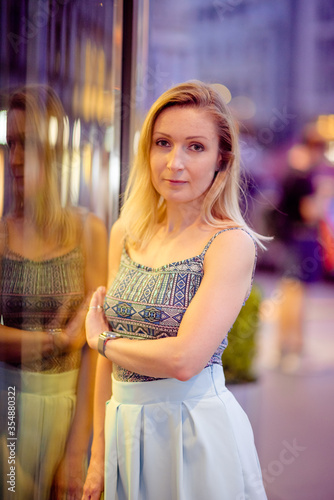 Young stylish beautiful woman walking in street, wearing dress and jacket, fashion outfit, spring and summer trend.