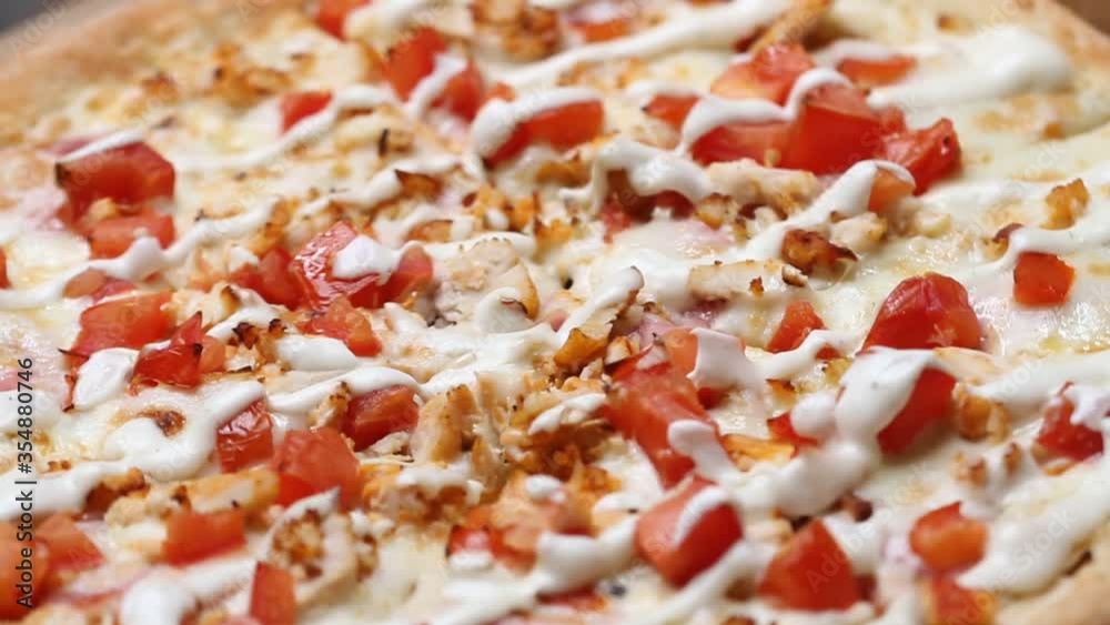 Hot Juicy tasty pizza with cheese, vegetables and sauce rotates in a circle on table close up. Macro shot. Hot Juicy tasty pizza with cheese, vegetables and sauce rotates in a circle on table close up. Macro shot.