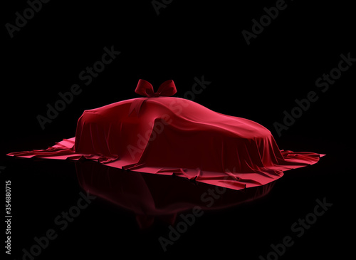 Car covered by red velvet fabric with gift bow-knot on a black background. Red cloth