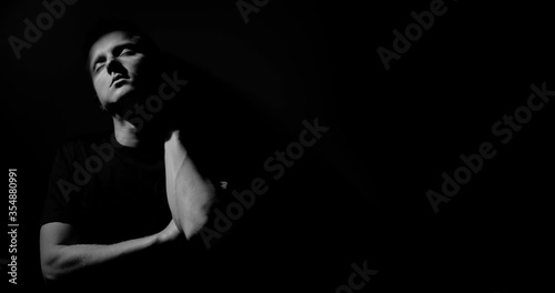 The guy rubs his neck and sighs. He leaned against the wall. copy space, abstraction