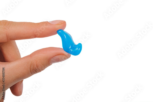 Isolated on white earplug in female hand for children. Personally molded earplugs close-up. Part of the set