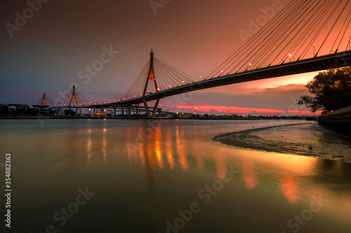 The blurred background of the twilight evening by the river, the natural color changes, the bridge over the river (Bhumibol Bridge) is one of the major transportation bridges in Bangkok, Thailand © bangprik