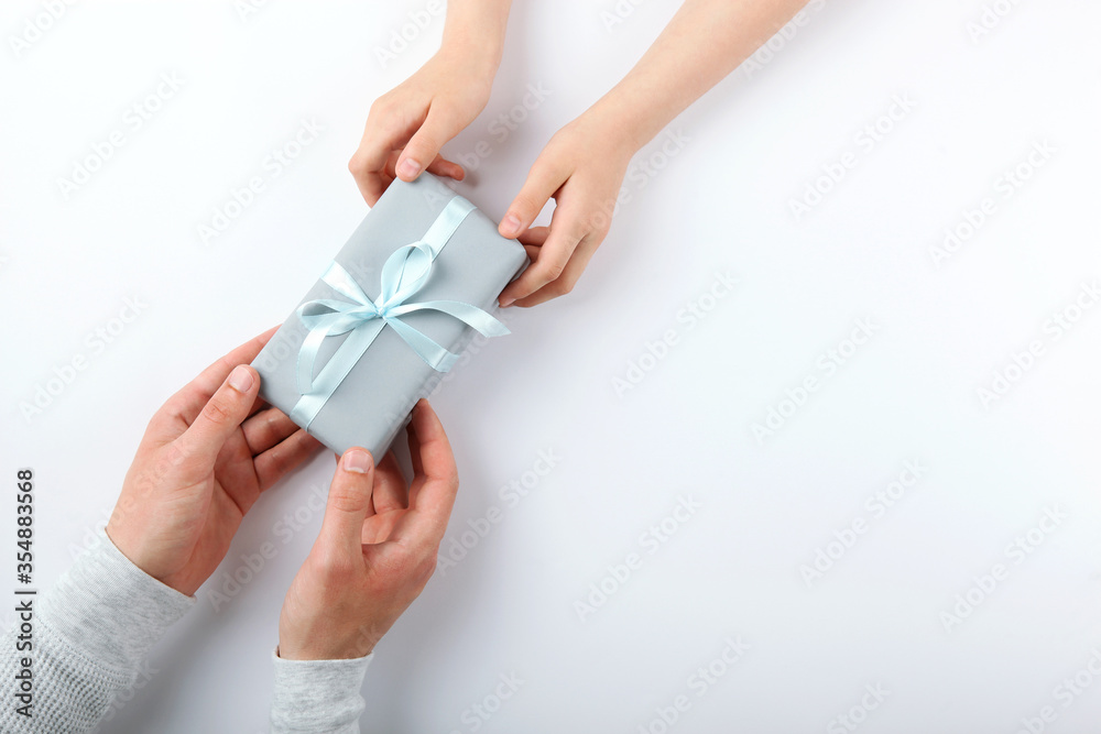 hands of a man and a reenka holding a gift top view. Father's Day Concept. place for text
hands of a man and a reenka holding a gift top view. Father's Day Concept. place for text