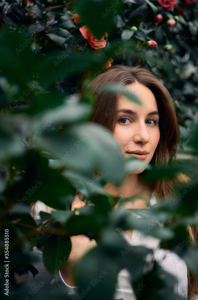 portrait of a young woman posing in leaves at the greenhouse portrait of a young woman posing in leaves at the greenhouse