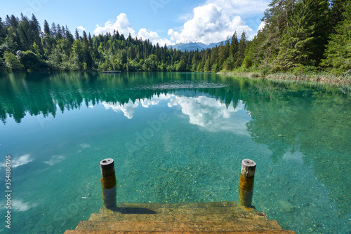Landscape panorama of Crestasee - Lake Cresta in June, municipalities of Flims and Trin in the Grisons, Switzerland. Wooden dock on the lake.       photo