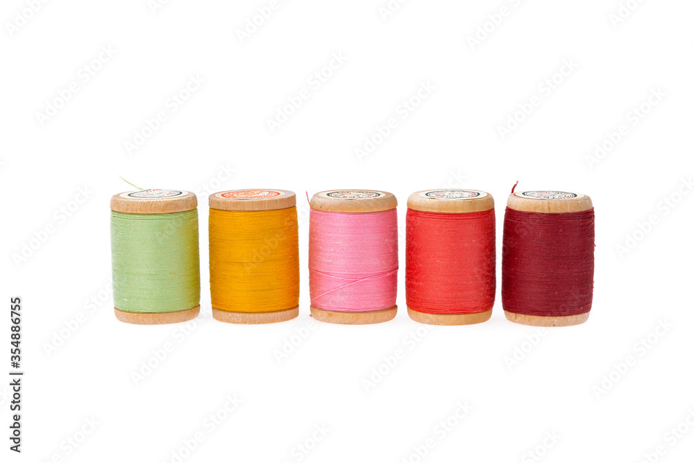 Colorful thread on a wooden spool. Isolated bobbins. White isolated background. Retro style bobbins. Close up Colorful thread on a wooden spool. Isolated bobbins. White isolated background. Retro style bobbins. Close up
