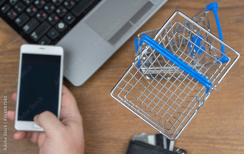 man orders a product on a cell phone. shopping cart. selective focus. online shopping.