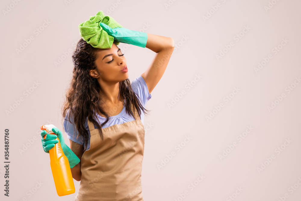 Portrait of african-american professional maid who is tired of cleaning. Portrait of african-american professional maid who is tired of cleaning.