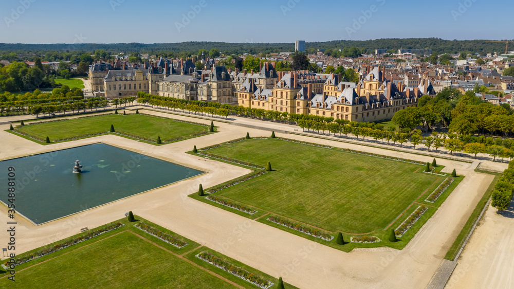 Fototapeta premium Aerial view of medieval landmark royal hunting castle Fontainbleau near Paris in France and lake with white swans