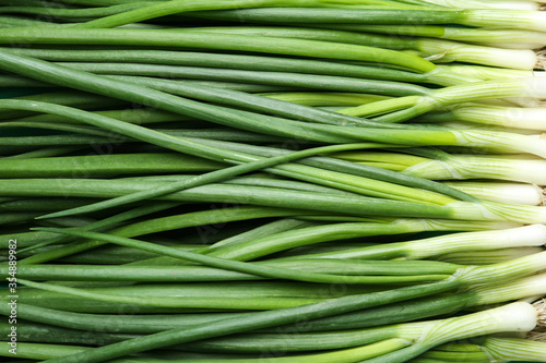 Φωτογραφία Fresh green spring onions as background, top view