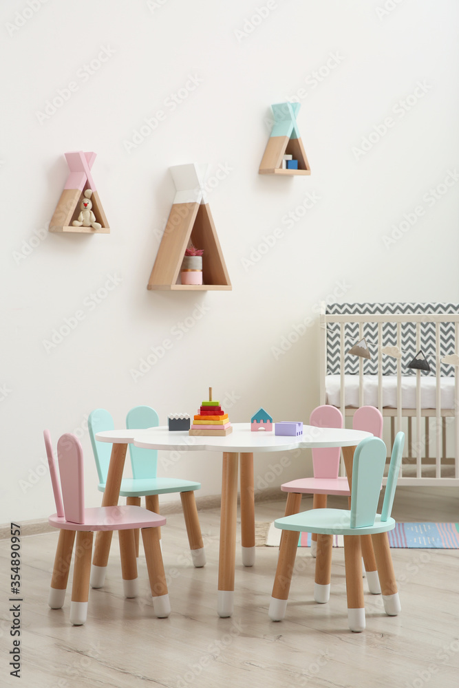 Obraz premium Little table and chairs with bunny ears in baby room. Interior design