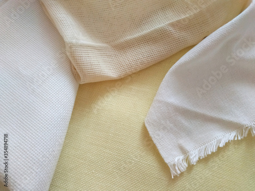 White, beige and yellow canvas close up. Bright fabric texture background