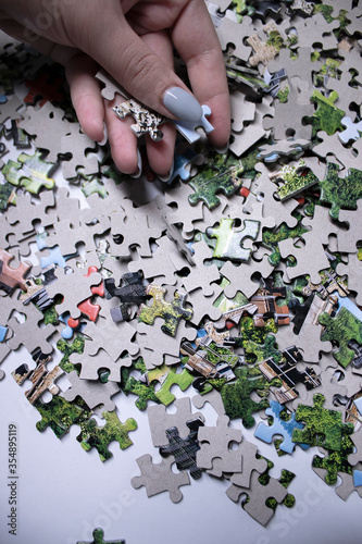 hand holding multicoloured puzzles on a white background. isolated. Top view, copy space.