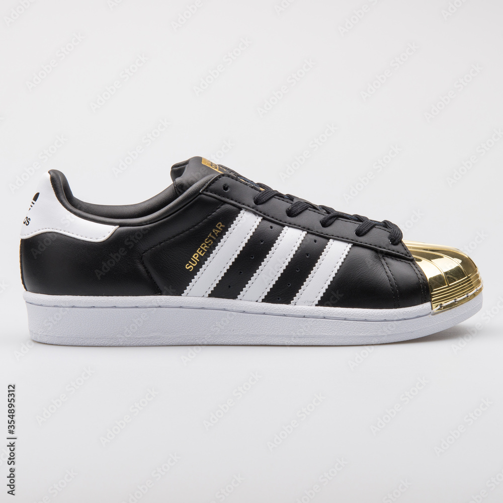 VIENNA, AUSTRIA - AUGUST 7, 2017: Adidas Superstar Metal Toe black and gold  sneaker on white background. Stock-Foto | Adobe Stock