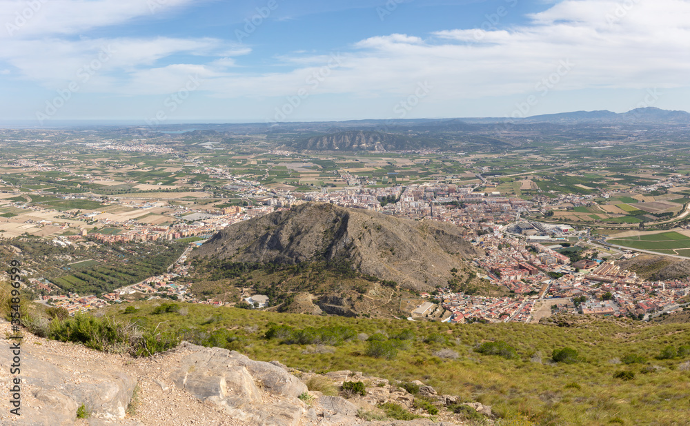 A view of the eastern Spanish city of Orihuela from a mountain. You can see all over the city. In the background is a reservoir and on the horizon the Mediterranean Sea. A view of the eastern Spanish city of Orihuela from a mountain. You can see all over the city. In the background is a reservoir and on the horizon the Mediterranean Sea.