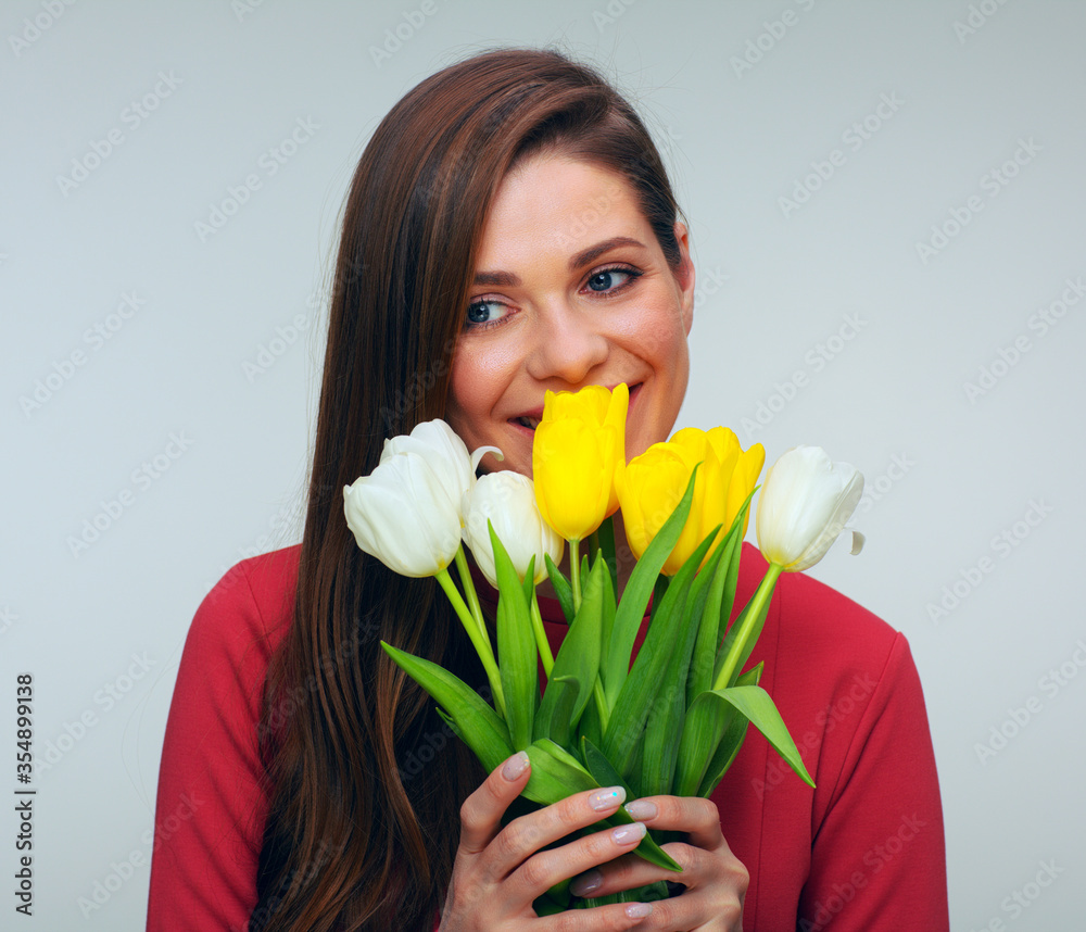 Young woman in red dress holding tulips flowers in front of herself Young woman in red dress holding tulips flowers in front of herself