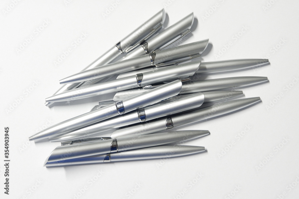 Group of silver pens are superimposed each other on white background. Concept for office equipment. Group of silver pens are superimposed each other on white background. Concept for office equipment.