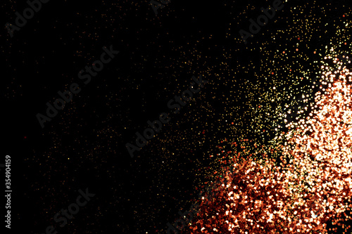 Shiny golden glitter scattered on a black background. Holidays concept.