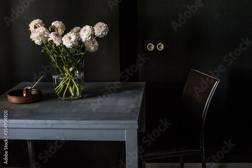Fototapeta Naklejka Na Ścianę i Meble -  Interrior fragment of the dark room with grey table, brown chair, vaze with dahlia flowers and coffie