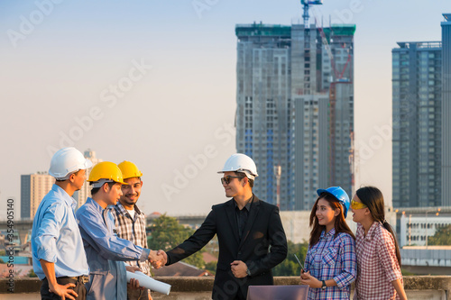 Business partnerchip concept. Business man and engineer making handshake together to agree joint business at construction site. photo