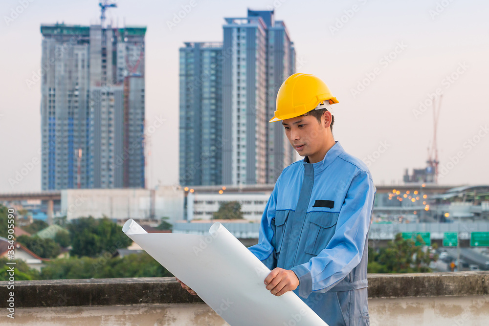 Worker with helmet looking paper plans at construction site. Worker with helmet looking paper plans at construction site.