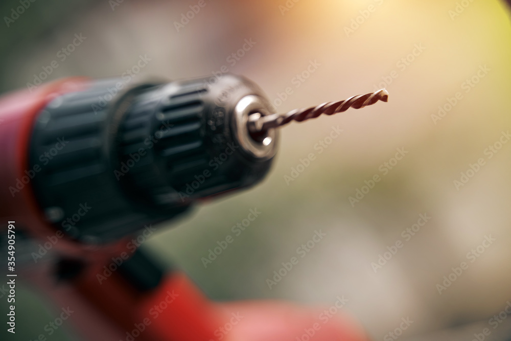 close up of drill bit on drill instrument. professional tool. woodwork static. screwdriver outdoor on blurred background