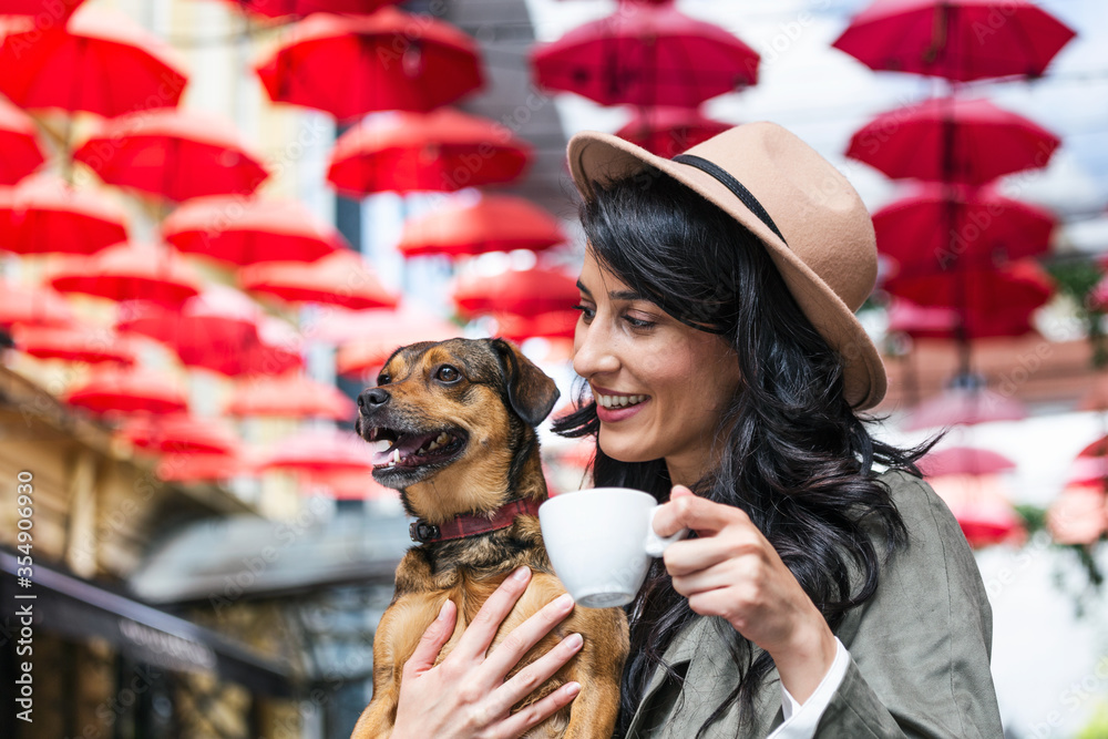 Young woman with her dog in pet friendly cafeteria. Girl drinking coffee at  local coffee shop with her pet dog Stock Photo | Adobe Stock