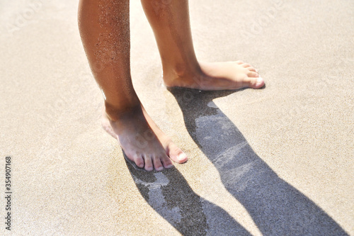 Female legs on sand texture.