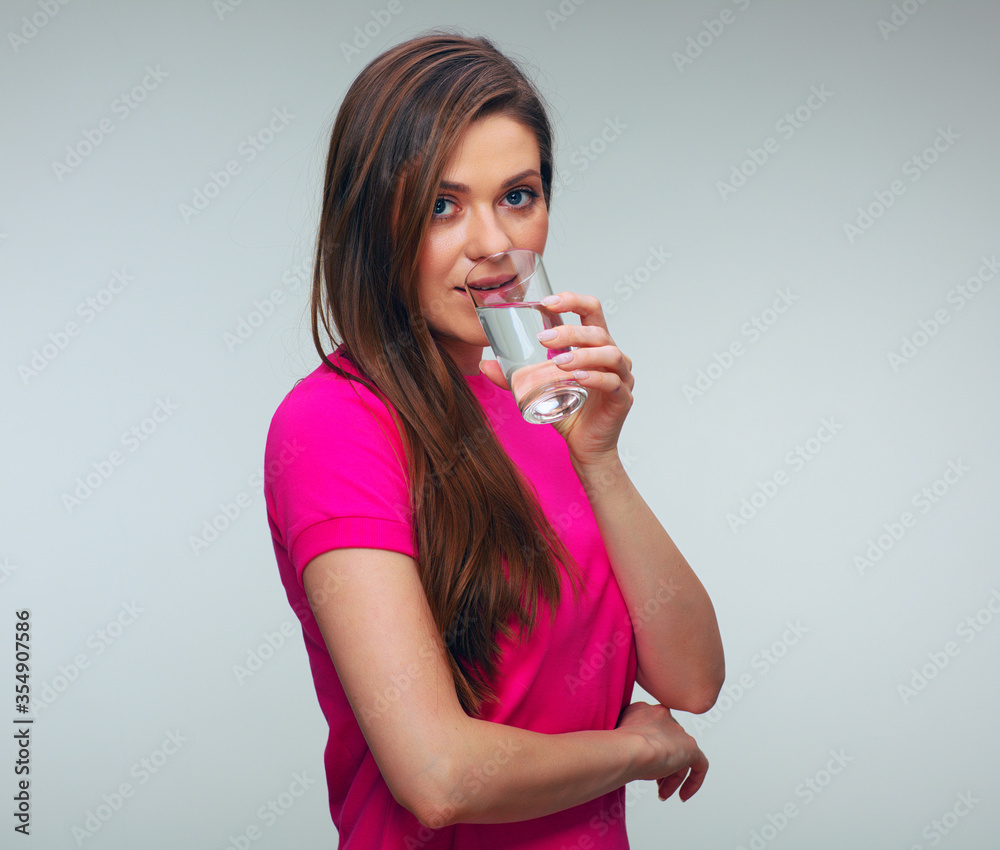 Smiling woman in red dress drinking water from glass. Smiling woman in red dress drinking water from glass.