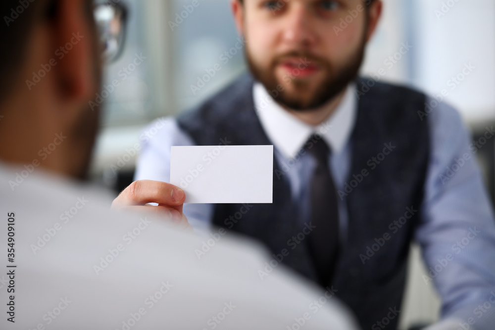 Male arm in suit give blank calling card to visitor Male arm in suit give blank calling card to visitor
