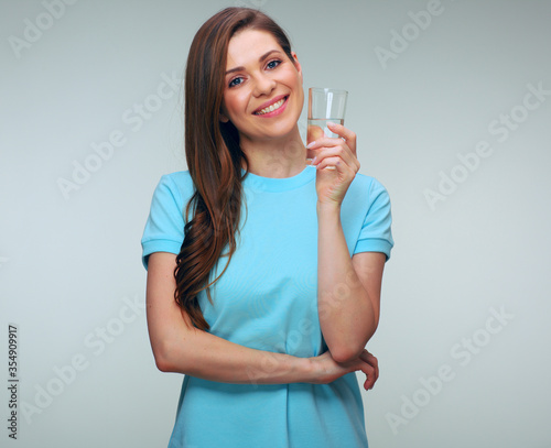 Woman in bblue dress holding water glass.