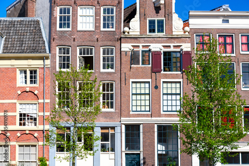 Old vintage colorful houses in Amsterdam, Netherlands with trees