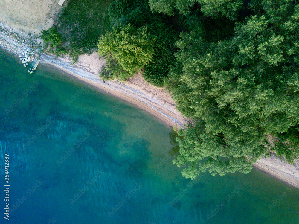 Aerial top view from abode (drone) sand beach and green trees, sea bay background