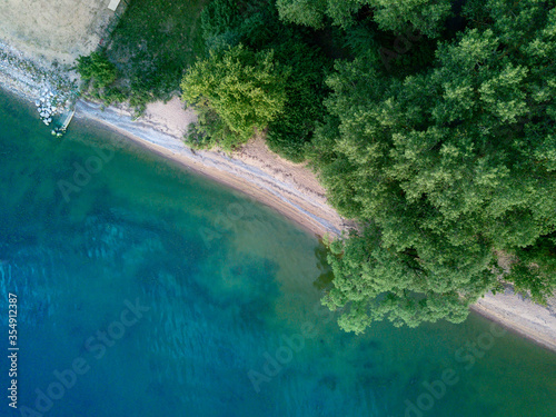 Aerial top view from abode (drone) sand beach and green trees, sea bay background