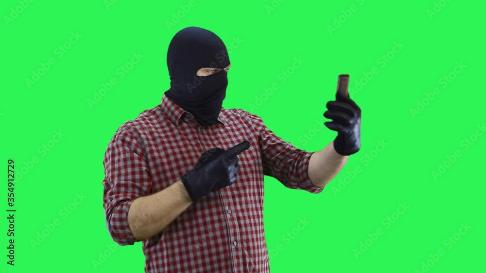 A man in a balaclava in a plaid shirt is talking on the phone by video link in a dialogue with the interlocutor, curses with him. A man in a balaclava in a plaid shirt is talking on the phone by video link in a dialogue with the interlocutor, curses with him.