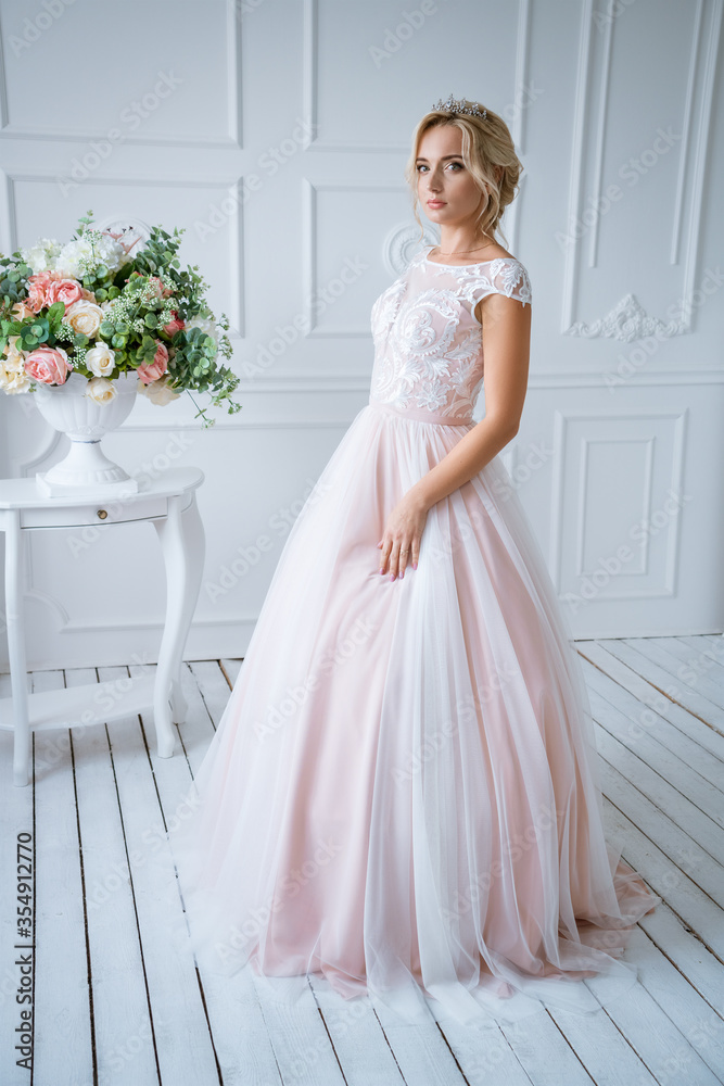 the bride is standing in a delicate pink wedding dress the bride is standing in a delicate pink wedding dress