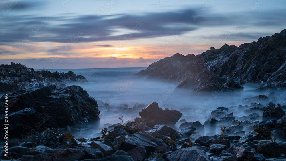 Moody sunrise over the sea and rocks