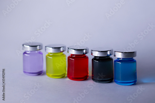 Little bottles with multicoloured liquid on white-gray background. Isolated. Board games. Cure - medicine, vaccine. Coronavirus or covid-19 - pandemic. High quality photo