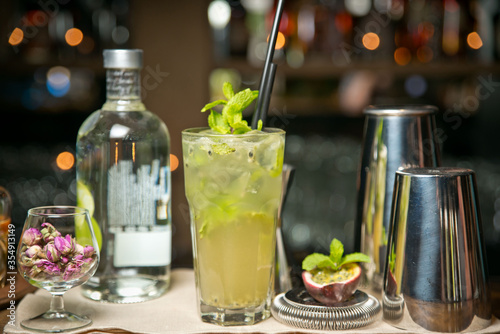 A Mojito cocktail with figs and roses On a wooden tray. Against the background of a restaurant bar